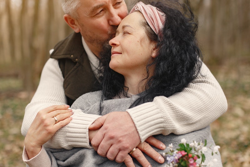 Confident man kissing wife after gaining confidence with benzocaine wipes