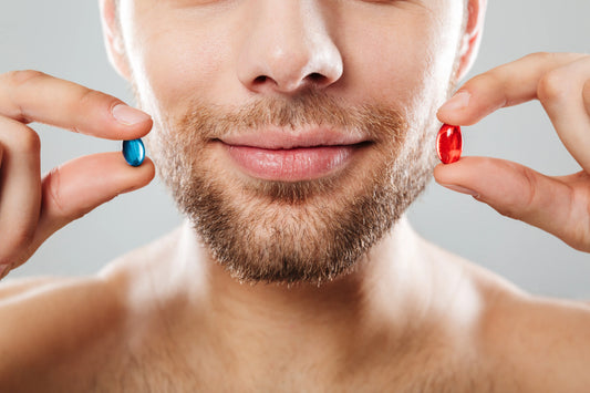 A man holds a blue and a red pill, representing prescription vs. over-the-counter ED medication