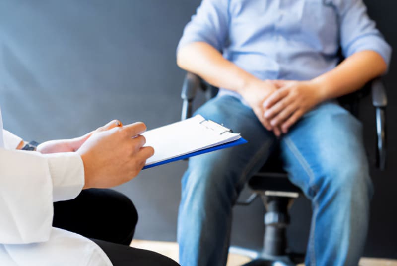 Man discussing whiskey dick with doctor