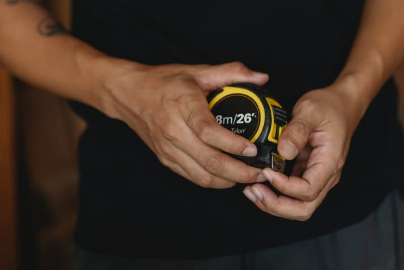 Man holding tape measure to measure the success of jelqing