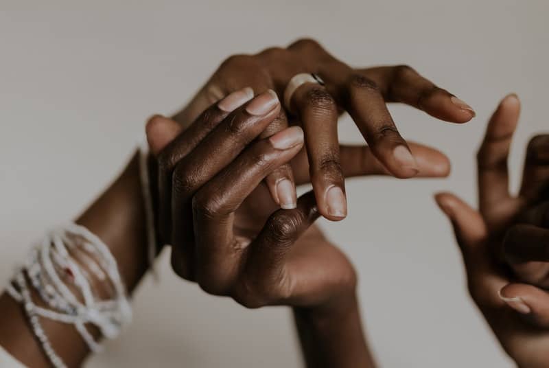 3 hands touching one another sensually to imply using your hands elsewhere during male g-spot play